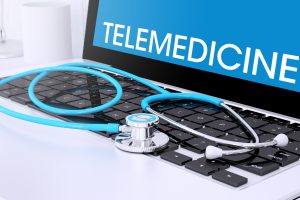 3d rendering of stethoscope on a laptop keyboard with screen showing telemedicine